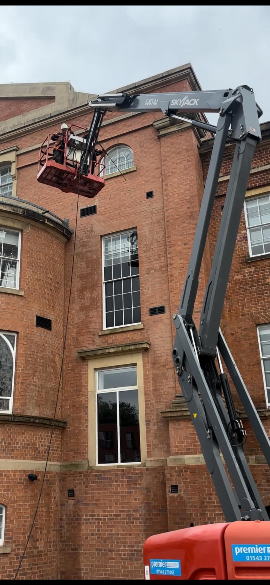 Pressure washing walls from a crane